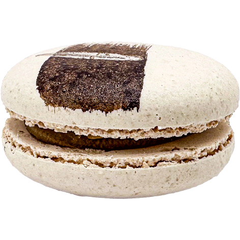 A light coloured macaron with a painted swipe of dark coffee and a dark coffee filling