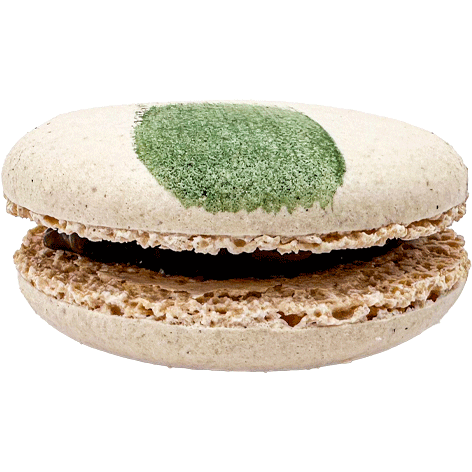 A light coloured macaron with a painted swipe of green and a dark filling